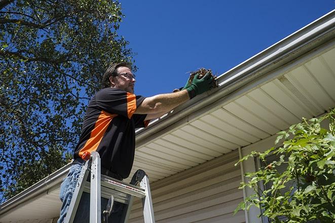 roofing technician replacing a rusted and leaking gutter in Altamonte Springs FL